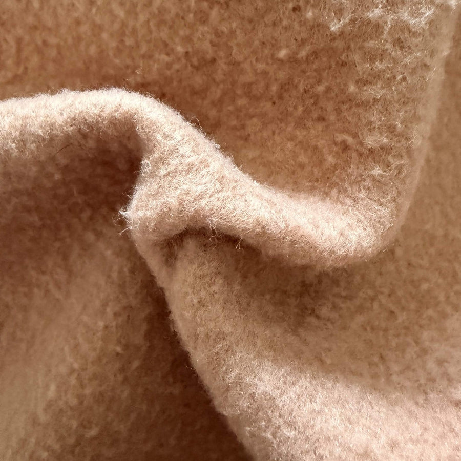 Close-up of 320gsm brushed cotton fleece folded to show the pile depth and thickness at the edge